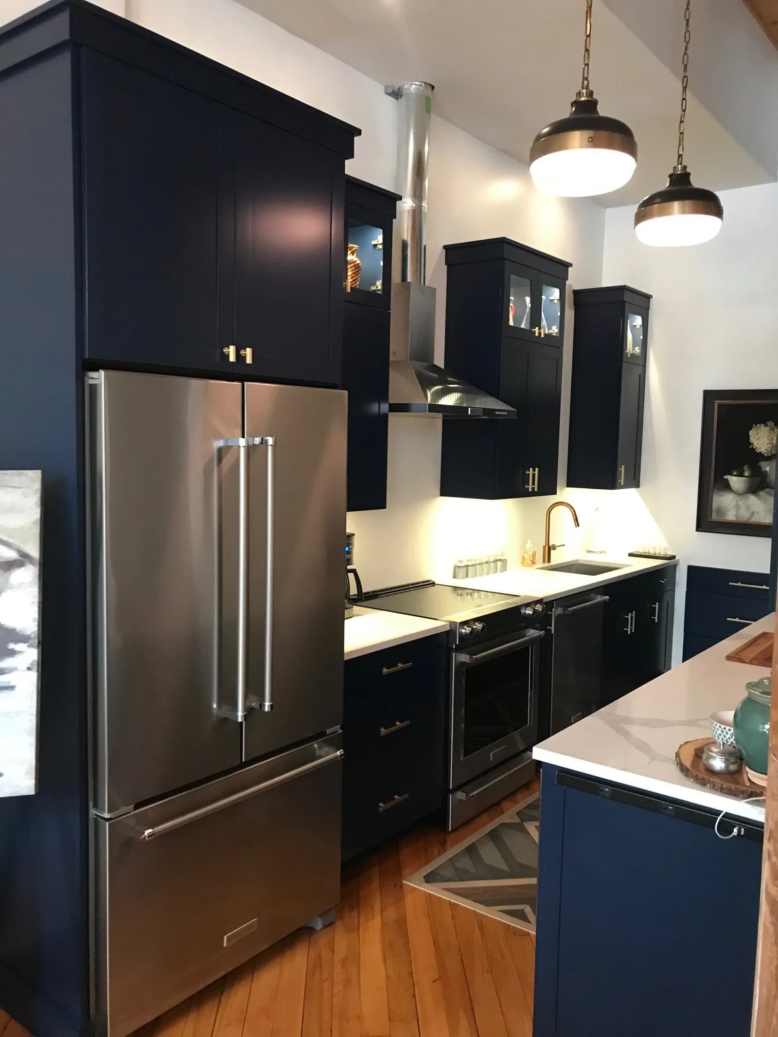 Andover MA kitchen — navy blue shaker cabinets, white quartz countertops, brass hardware, stainless French-door refrigerator