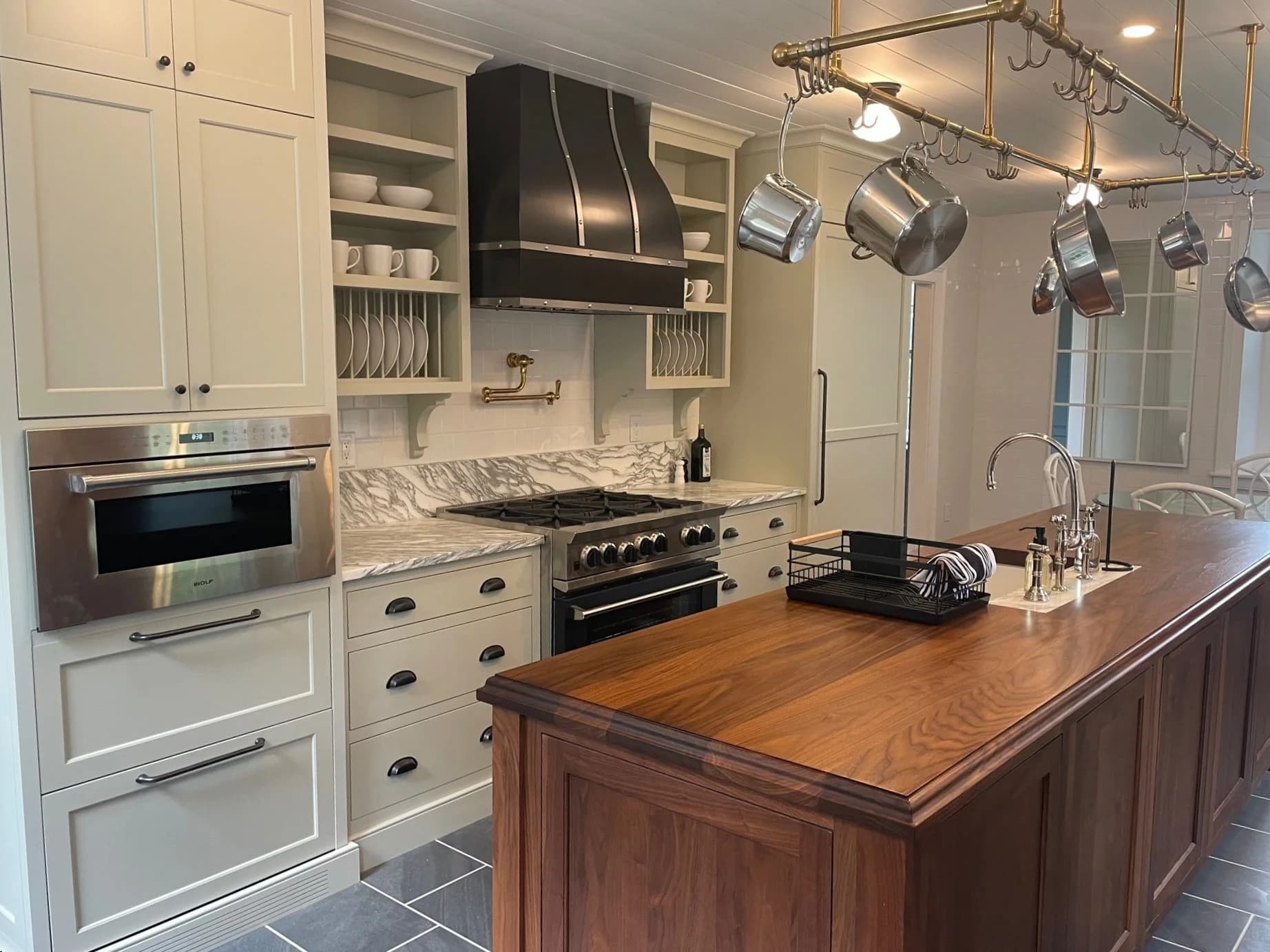 Harvard MA kitchen — cream inset cabinets, walnut island, marble counters, black range hood