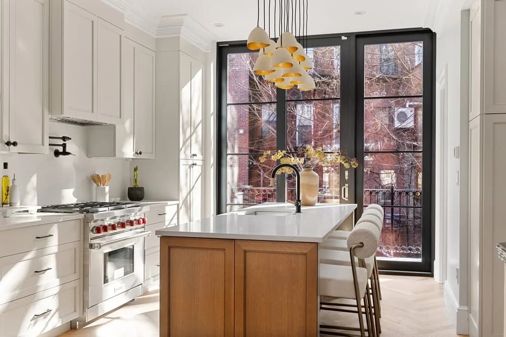 South Boston MA kitchen — white shaker cabinets, natural oak island, quartz counters, floor-to-ceiling steel windows