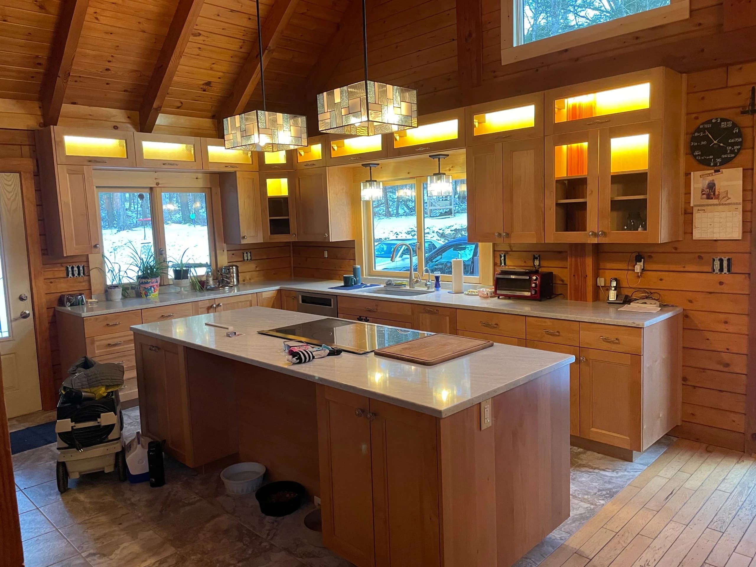 Stratham NH kitchen — natural maple shaker cabinets, white quartz island, cathedral timber-frame ceiling